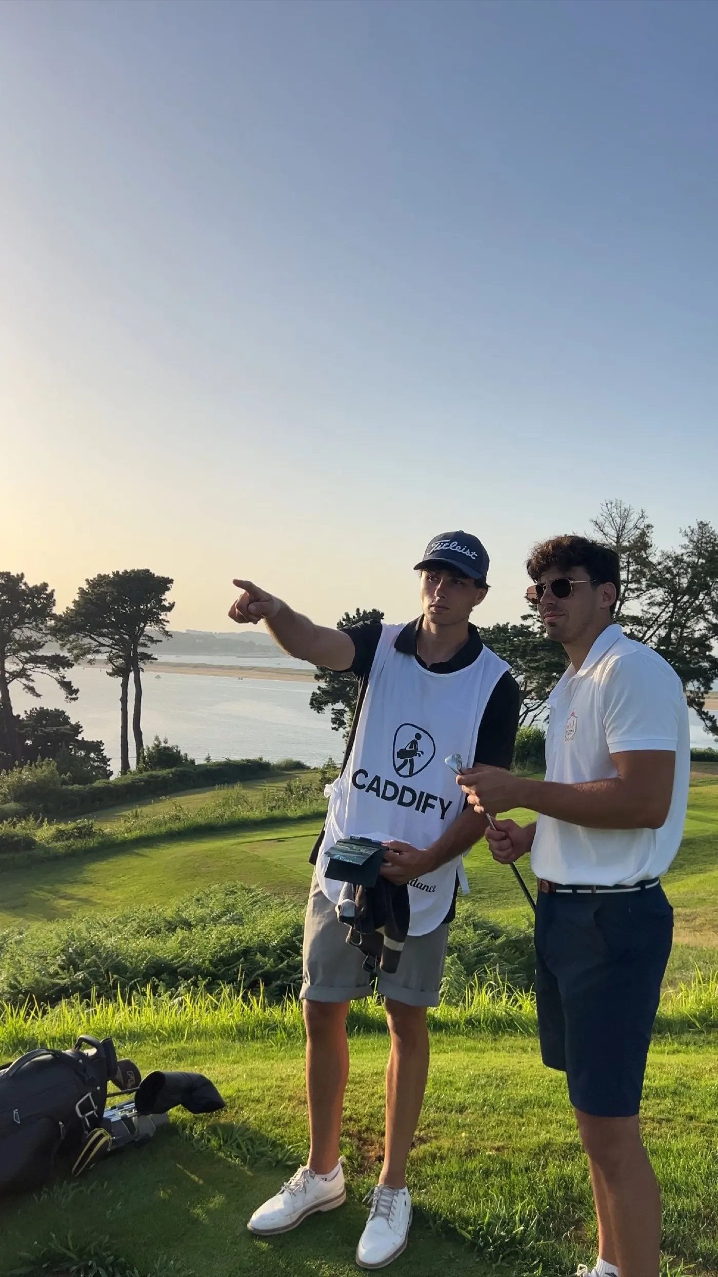 Caddie señalando la calle a un jugador junto al mar